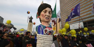 Protesters carry an effigy of South Korea's President Park Geun-Hye during a rally against Park in central Seoul on December 3, 2016. Hundreds of thousands of protestors marched in Seoul for the sixth-straight week on December 3, to demand the ouster and arrest of scandal-hit President Park Geun-Hye ahead of an impeachment vote in parliament. / AFP PHOTO / JUNG Yeon-Je